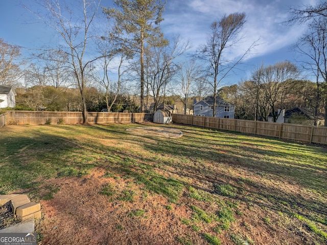 view of yard with an outbuilding, a fenced backyard, and a shed