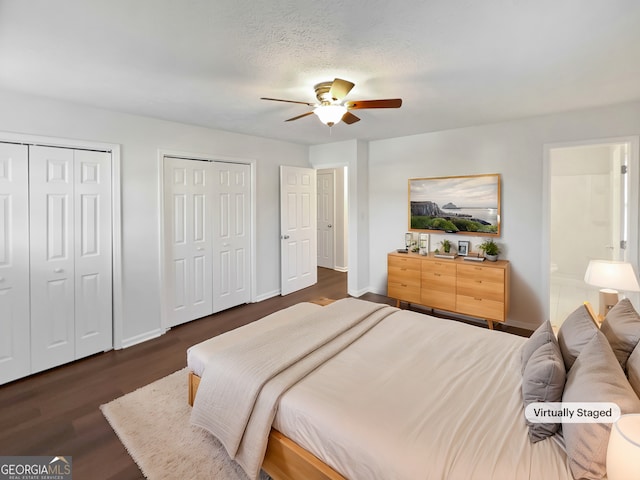 bedroom featuring dark wood-style floors, ceiling fan, two closets, and baseboards