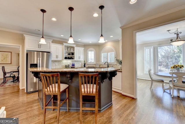 kitchen featuring white cabinetry, stainless steel refrigerator with ice dispenser, and a sink