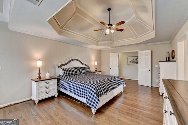 bedroom featuring crown molding, wood finished floors, baseboards, and coffered ceiling