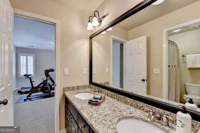 full bathroom featuring double vanity, toilet, visible vents, and a sink