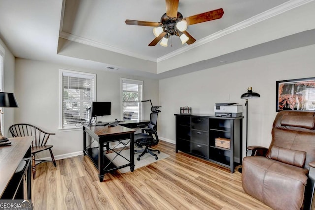 office with baseboards, light wood-type flooring, a tray ceiling, and ornamental molding