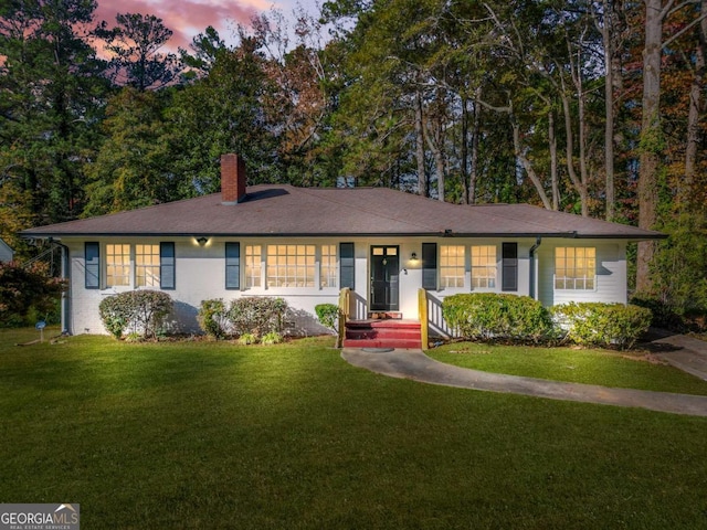 ranch-style home with a front lawn and a chimney