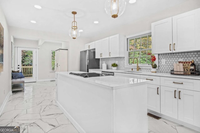 kitchen with a center island, baseboards, freestanding refrigerator, marble finish floor, and a sink