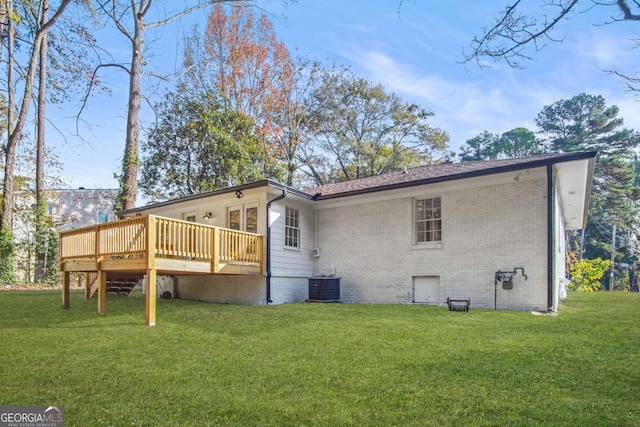 rear view of property featuring brick siding, central AC, a deck, and a lawn