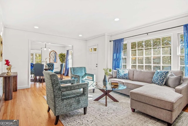 living area with recessed lighting, baseboards, an inviting chandelier, and light wood finished floors