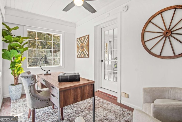 office area with baseboards, crown molding, and a ceiling fan