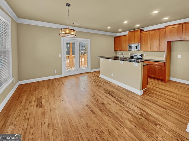 kitchen with brown cabinets, dark countertops, stainless steel appliances, light wood-style floors, and baseboards