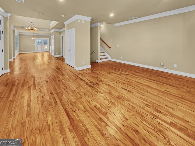 unfurnished living room featuring light wood-type flooring, stairway, an inviting chandelier, crown molding, and baseboards