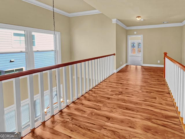 hall with baseboards, wood finished floors, and ornamental molding