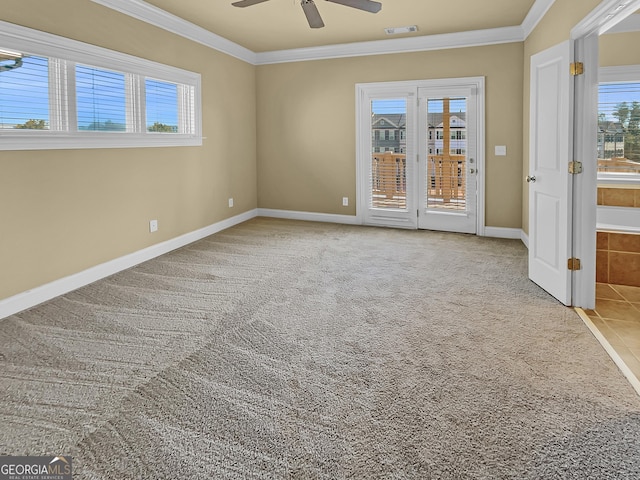 spare room with visible vents, ornamental molding, carpet, baseboards, and ceiling fan