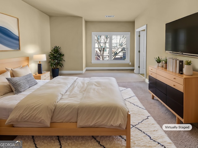 bedroom featuring baseboards, visible vents, and light carpet