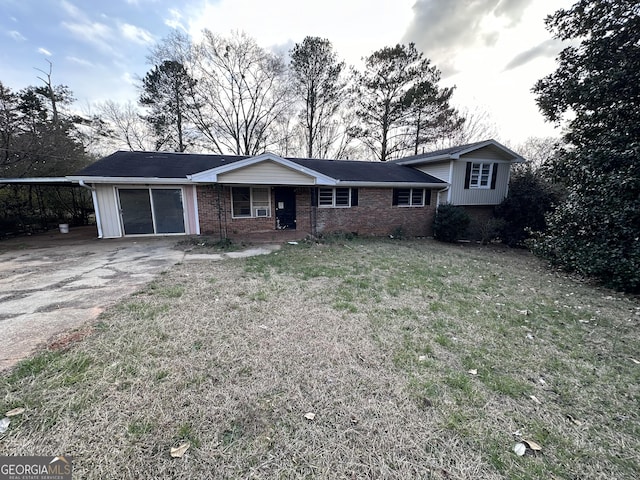 view of front of home with a garage, brick siding, concrete driveway, and a front lawn