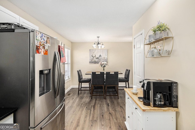 dining space featuring an inviting chandelier, baseboards, and wood finished floors