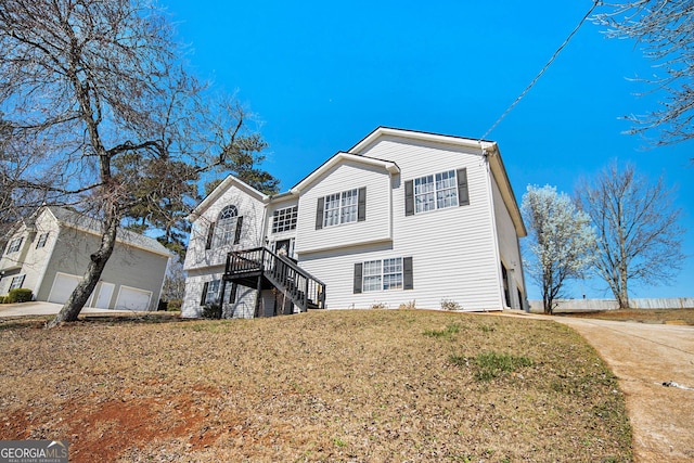 view of front facade featuring stairway, a garage, and a front lawn