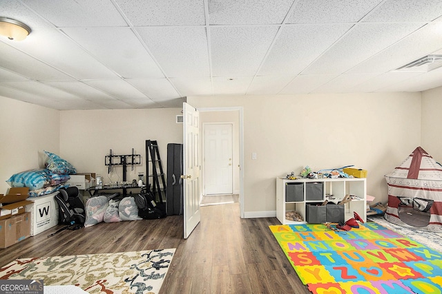 playroom with visible vents, a drop ceiling, baseboards, and wood finished floors