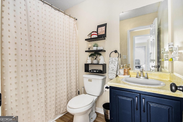 full bath featuring vanity, curtained shower, toilet, and wood finished floors