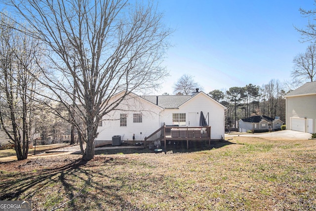 back of house with central AC unit, a lawn, a chimney, and a deck