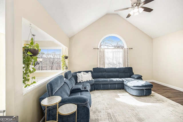 living area featuring baseboards, wood finished floors, a ceiling fan, and vaulted ceiling