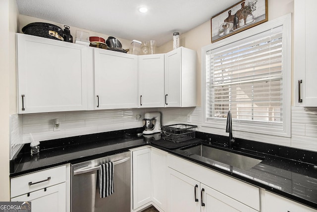 kitchen featuring a sink, decorative backsplash, dishwasher, and white cabinets