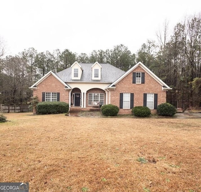 view of front facade featuring brick siding and a front yard