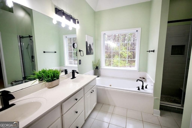 bathroom with tile patterned floors, a stall shower, a jetted tub, and a sink