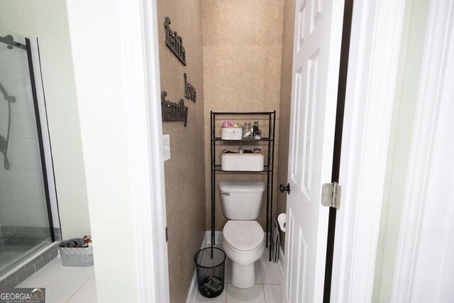 full bathroom with tile patterned flooring, a stall shower, and toilet