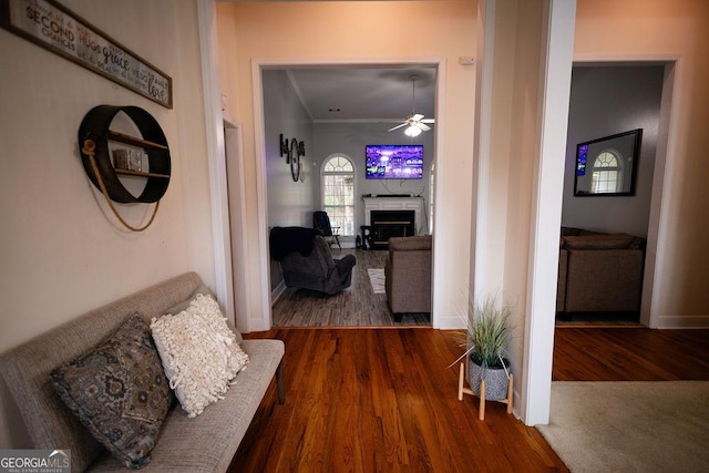 hall with crown molding, wood finished floors, and baseboards