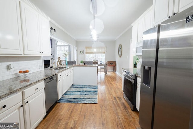 kitchen with a sink, appliances with stainless steel finishes, ornamental molding, and white cabinets