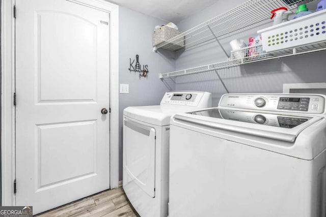 laundry room featuring washing machine and clothes dryer, laundry area, and light wood-style floors