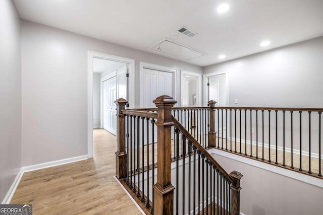 corridor featuring baseboards, attic access, an upstairs landing, recessed lighting, and light wood-style flooring