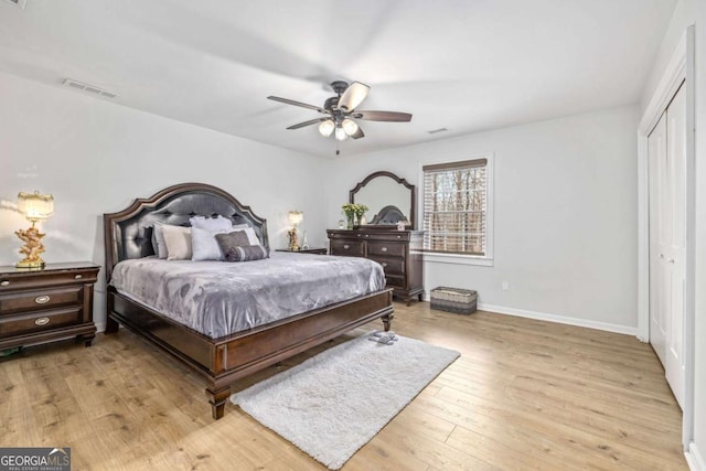 bedroom with light wood-style flooring, baseboards, visible vents, and a closet