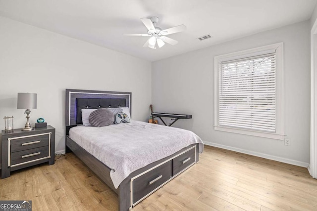 bedroom featuring visible vents, ceiling fan, baseboards, and light wood-style floors