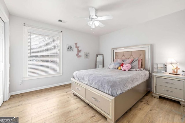 bedroom featuring visible vents, baseboards, a ceiling fan, and light wood finished floors