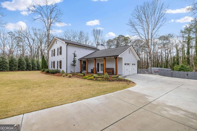 view of front of home featuring an attached garage, driveway, a chimney, and a front yard