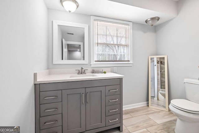 full bath featuring visible vents, toilet, baseboards, walk in shower, and vanity