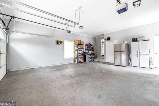 garage with a garage door opener and freestanding refrigerator