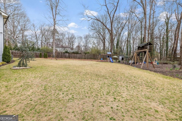 view of yard with a playground and fence