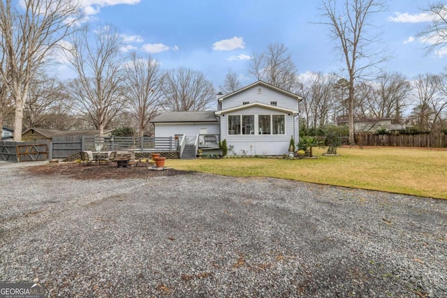 view of front facade with a deck, a front yard, and fence