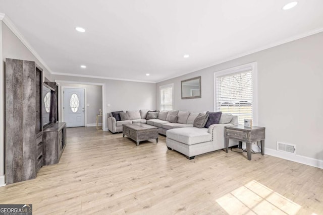 living room with crown molding, light wood-style flooring, and a healthy amount of sunlight