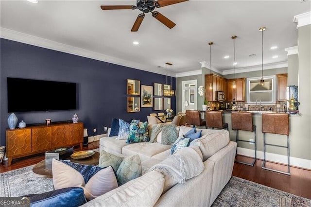 living room with recessed lighting, baseboards, wood finished floors, and crown molding