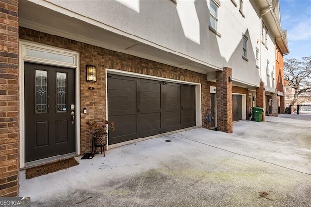 doorway to property with brick siding and a garage