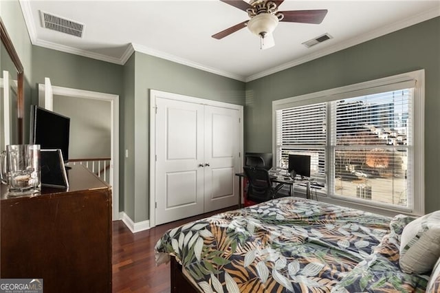 bedroom with crown molding, wood finished floors, visible vents, and a closet