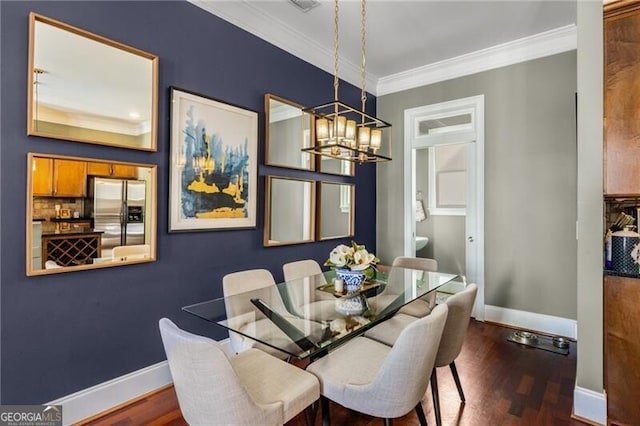 dining room with an inviting chandelier, wood finished floors, baseboards, and ornamental molding