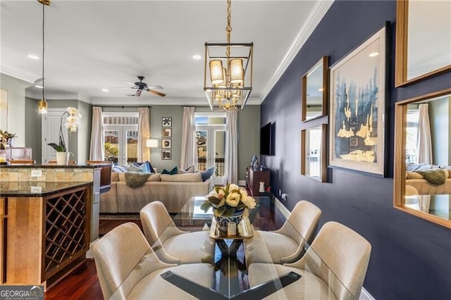 dining area with ceiling fan with notable chandelier, dark wood finished floors, recessed lighting, crown molding, and baseboards