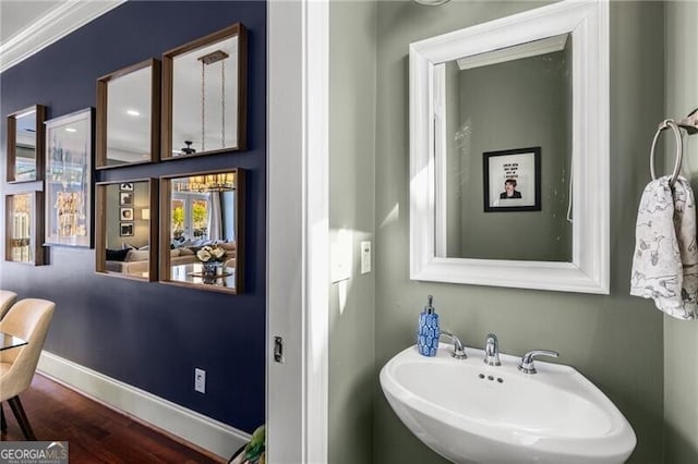 bathroom featuring a sink, baseboards, and wood finished floors