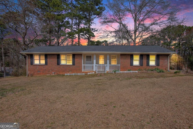 single story home with crawl space, a yard, covered porch, and brick siding