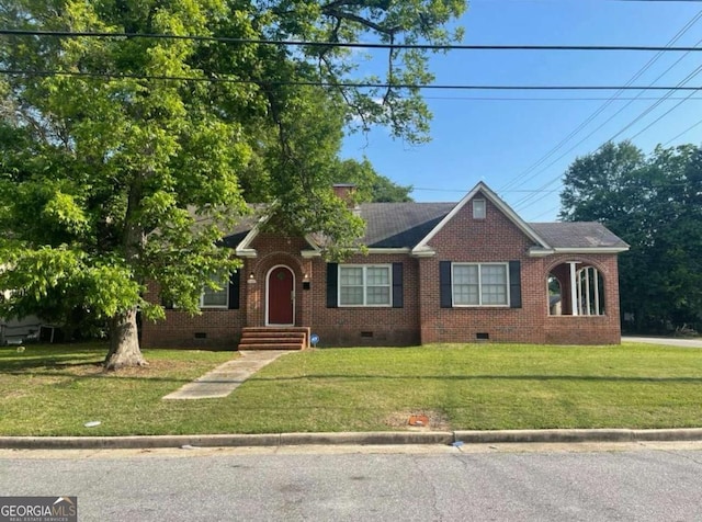 ranch-style home featuring a front yard, brick siding, roof with shingles, and crawl space