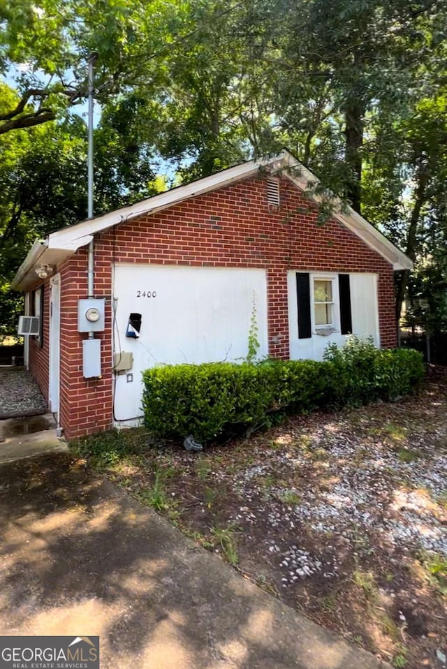 view of side of property featuring cooling unit and brick siding