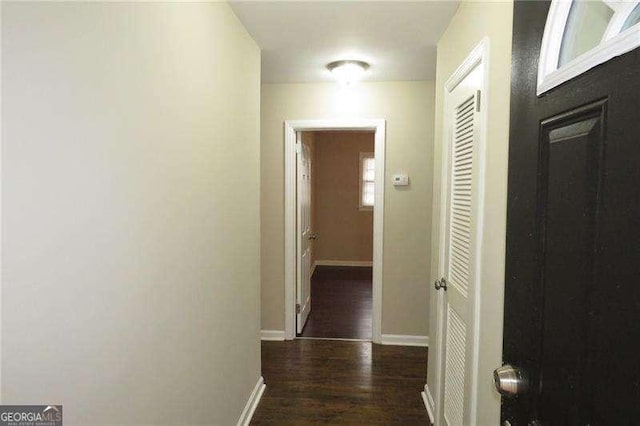 hall featuring baseboards and wood finished floors